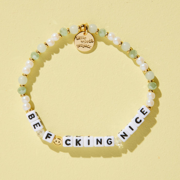 Bracelet with letter beads spelling 'BE F*CKING NICE' on a yellow background