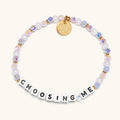 Bracelet with beads and a gold tag on a white background