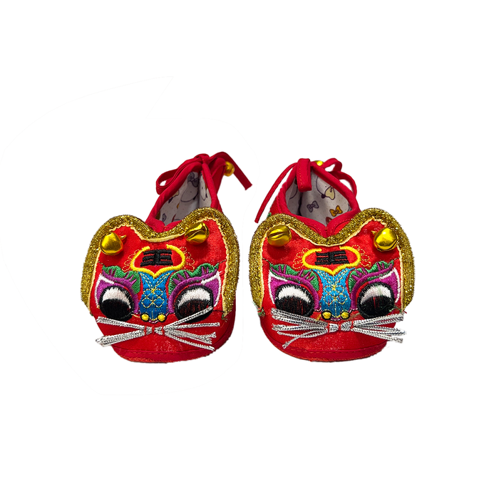 Pair of red tiger-shaped slippers with colorful faces on a white background