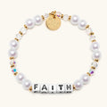 Pearl bracelet with gold accents and 'FAITH' beads on a white background