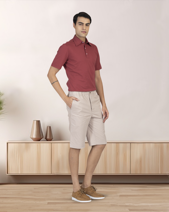 Model wearing custom Genoa shorts for men by Luxire in pale green wearing red top one hand in pocket