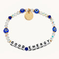 Bracelet with blue evil eye beads, clear crystals, gold charm, and 'GOOD ENERGY' tile beads on a white background