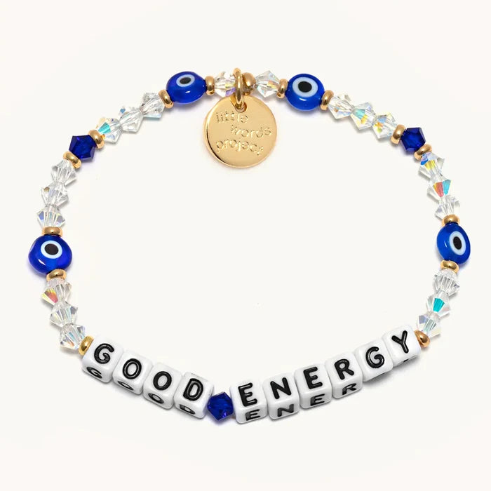 Bracelet with blue evil eye beads, clear crystals, gold charm, and 'GOOD ENERGY' tile beads on a white background