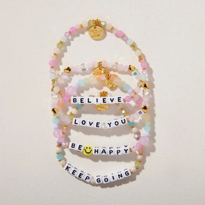 Set of colorful beaded bracelets with motivational phrases on a light background