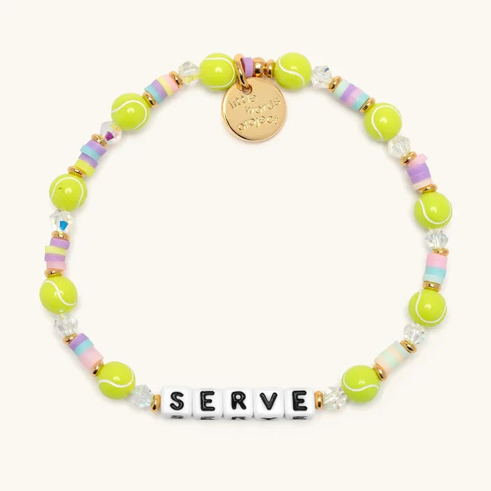 Serve tennis bracelet flat lay with neon tennis ball beads, pastel heishi discs, clear crystals, gold accents, and white letter beads spelling SERVE