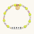 Serve tennis bracelet flat lay with neon tennis ball beads, pastel heishi discs, clear crystals, gold accents, and white letter beads spelling SERVE
