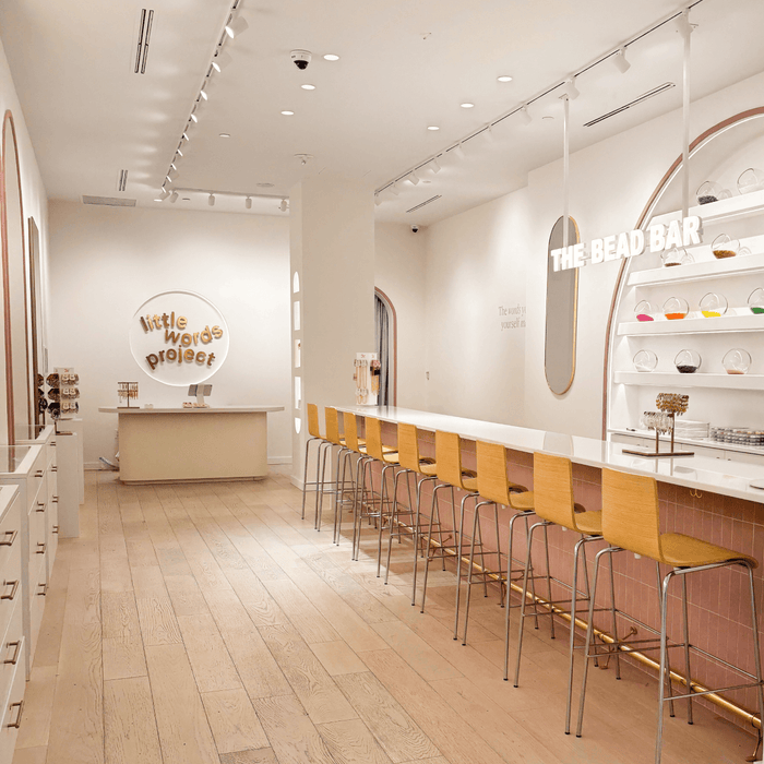 Modern interior design of a store with yellow stools and a counter.