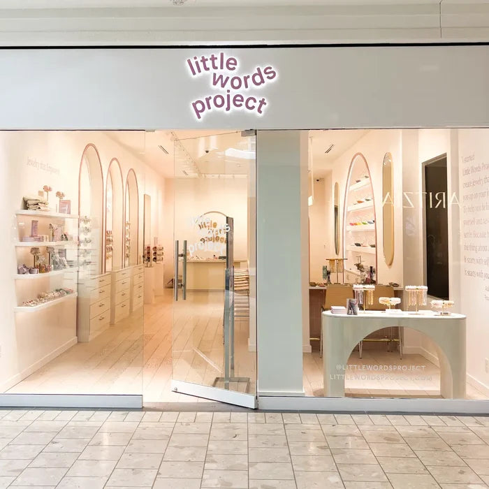 Storefront with 'little words project' sign, interior visible through glass doors.