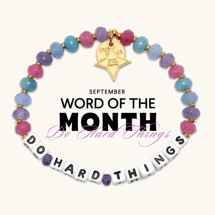 Do Hard Things September Word of the Month bracelet with white letter beads, pink, purple and blue faceted beads, and a gold Word of the Month star charm